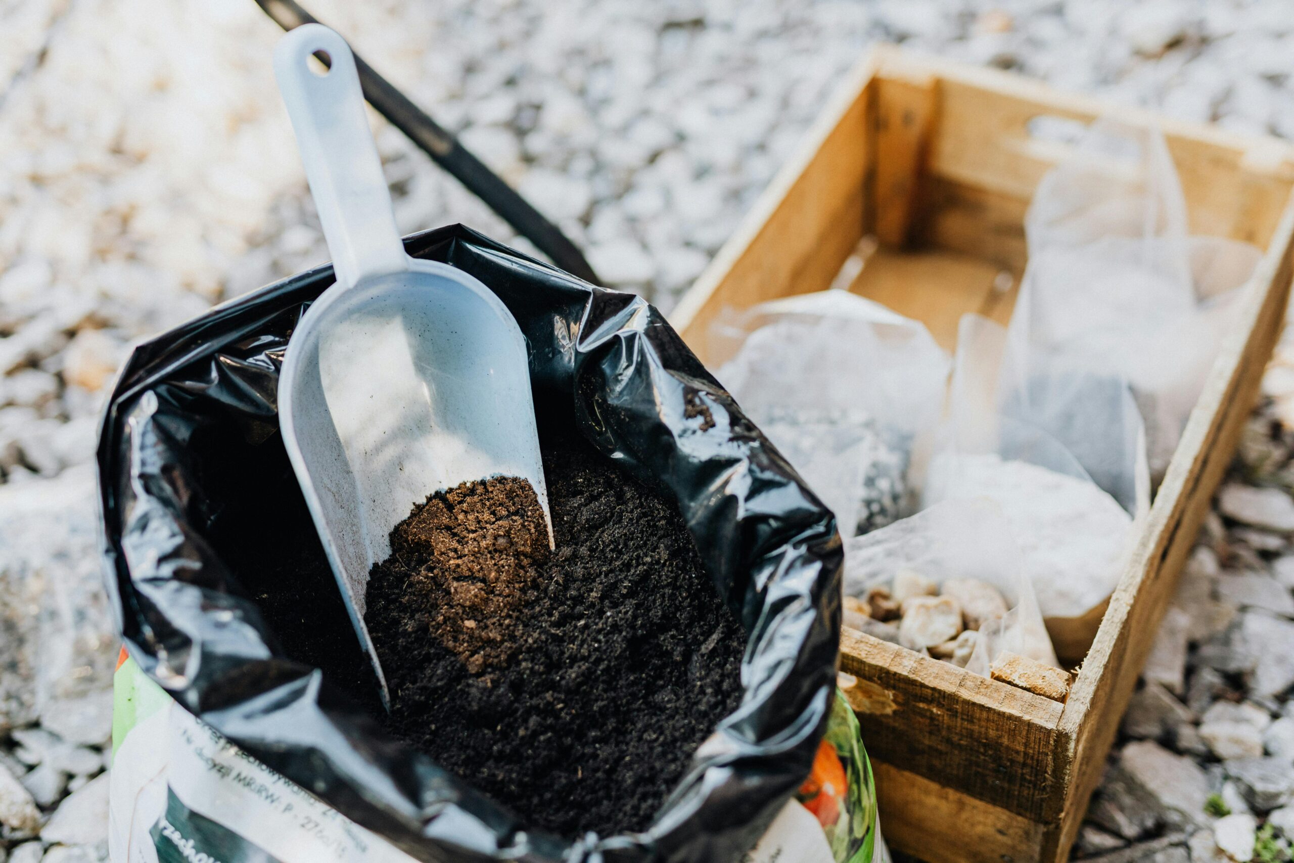 A bag of soil next to fertilizer